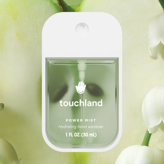 Touchland Power Mist hydrating hand sanitizer spray bottle displayed against soft floral green background.