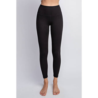 Woman wearing black high-waisted leggings standing against gray background, full-length athletic wear display.
