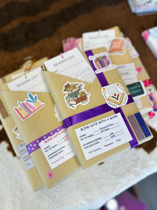 Wrapped books with purple ribbons and "Blind Date with a Book" labels featuring genre and page information.