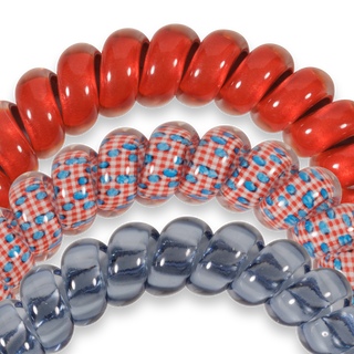 Three TELETIES hair ties in different patterns - solid red, gingham with blue dots, and translucent blue.