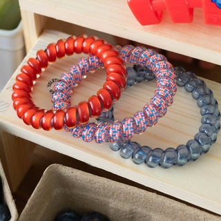Three TELETIES hair ties in different patterns displayed in a wooden drawer organizer.