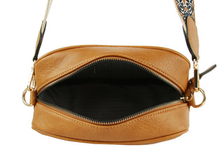 Open brown leather crossbody bag with patterned guitar strap showing black herringbone interior lining