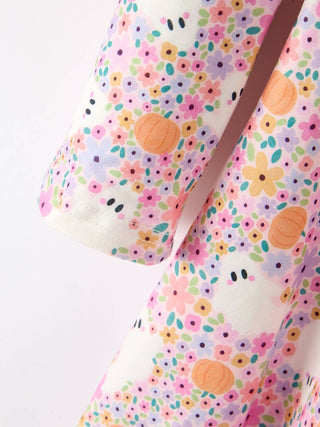 Close-up of a floral ghost and pumpkin print fabric on a girls twirl dress.