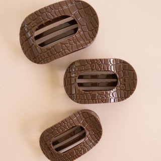 Three TELETIES flat round hair clips in a crocodile embossed finish, shown in varying sizes.
