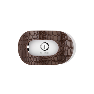 TELETIES flat round hair clip featuring a glossy crocodile embossed pattern with branded logo detail.
