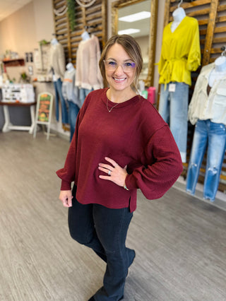 Woman wearing Blu Pepper cozy textured long sleeve top with balloon sleeves in a boutique.