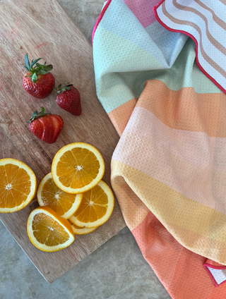 California Sunset Kitchen Towel with fresh strawberries and orange slices on wooden cutting board