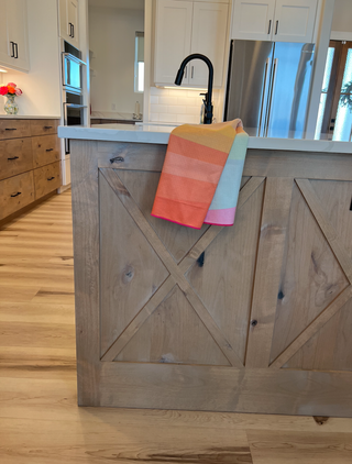 Colorful striped kitchen towel hanging on rustic wooden island in modern farmhouse kitchen