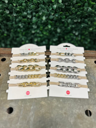 Ten chain-style hair tie bracelets in gold and silver tones displayed on white packaging cards.