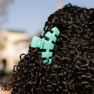 TELETIES Classic Hair Clip securing curly dark hair in an outdoor setting