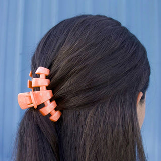 TELETIES Classic Hair Clip holding back dark brown hair against blue background