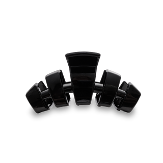 Five black hair clips arranged in a semi-circle on a black background
