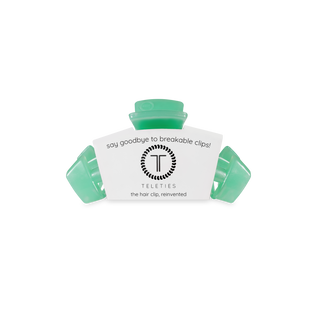 TELETIES classic hair clips in translucent green displayed in white branded packaging on black stand.