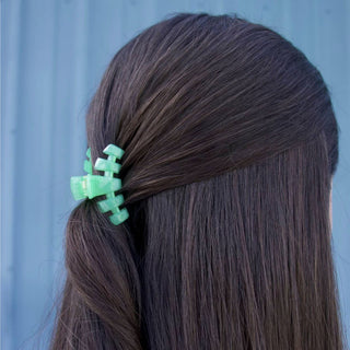TELETIES Classic Hair Clip holding back section of long brown hair against blue background
