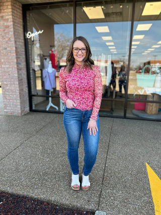 Woman wearing classic tummy control skinny jeans with floral top standing outside boutique storefront
