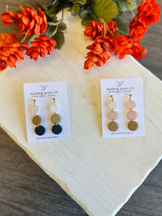Harper Klay Co. handcrafted triple circle drop earrings displayed on white cards with orange florals.
