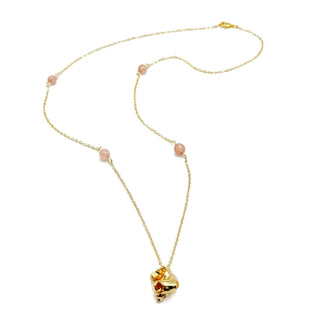 Gold chain necklace with pink beaded accents and conch shell pendant on white background
