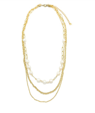Multi-layered gold chain necklace with white pearls on white background
