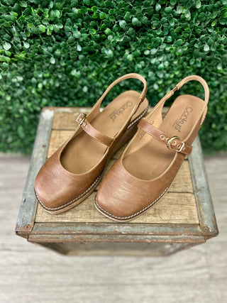 Corkys Pity Party leather Mary Jane wedge clogs with buckle strap displayed on rustic wooden crate.