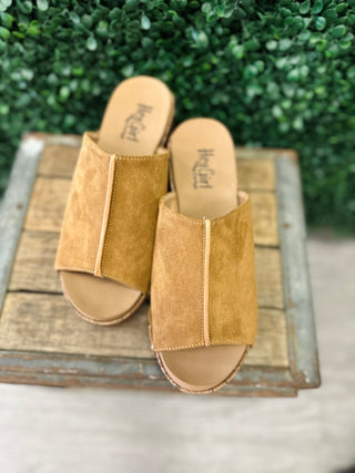 Corkys Gaslight suede wedge slide sandals with wide band strap displayed on rustic wood tray.
