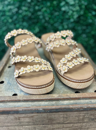 Corky's wedge sandals with floral embellishments and raffia platform soles on wooden surface