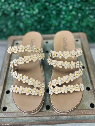 Corky's decorative wedge sandals with floral embellishments and multiple straps on wooden surface