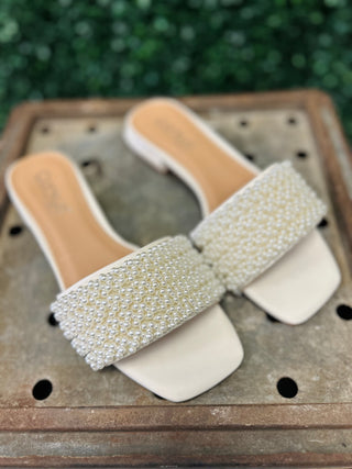 Corky's Our Lil Secret pearl-embellished slide sandals with square toe and block heel on wooden surface