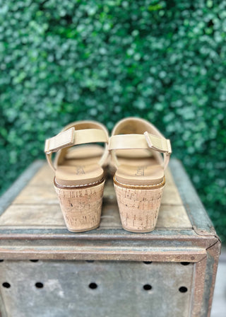 Corky's wedge sandals with cork heels and adjustable straps displayed on rustic wooden crate outdoors