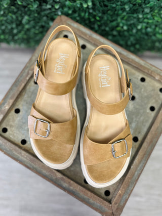 Corky's caramel brown sandals with ankle straps and buckle details displayed on wooden tray