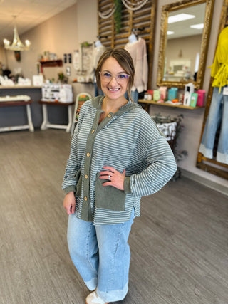 Woman wearing Haptics Cozy & Collected Striped Hoodie Top with wide-leg jeans in boutique setting.