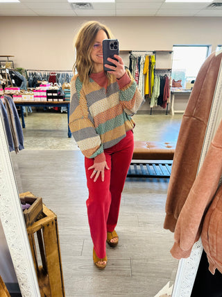 Woman wearing Haptics Cozy & Collected Striped Top with wide-leg pants, taking mirror selfie in boutique.