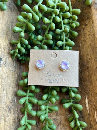 Crystal Halo Studs earrings on display card surrounded by green succulent plants on wooden surface