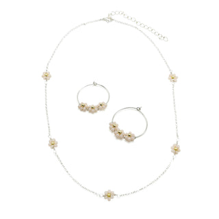 Silver chain necklace and matching hoop earrings with delicate daisy flower charms and gold accents.