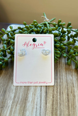 Gold geometric heart-shaped stud earrings displayed on Alegria accessories card with green succulent plant.