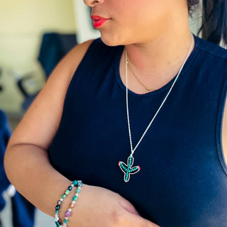 Woman wearing Alegria Accessories Desert Bloom Bracelet with matching turquoise necklace and navy top.