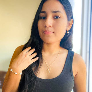 Woman wearing delicate dove pendant necklace with gold chain, showcasing elegant everyday jewelry styling.