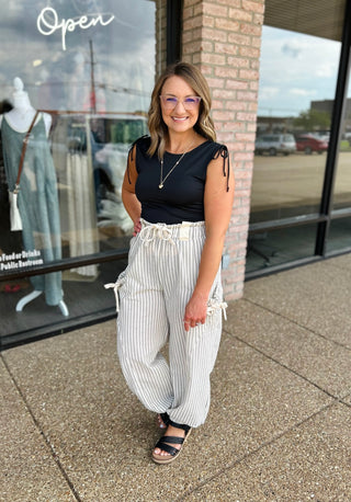Woman wearing VERY J Elevated Ease Striped Joggers with drawstring waist and tie side pockets.