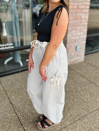 Woman wearing VERY J Elevated Ease Striped Joggers with tie details, paired with black tank top.