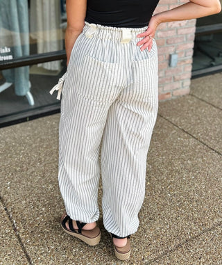 Woman wearing VERY J Elevated Ease Striped Joggers with elastic waistband, paired with black wedge sandals.