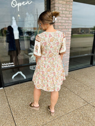Woman wearing VERY J Fall Feels Floral Mini Dress with puff sleeves, shown from behind.