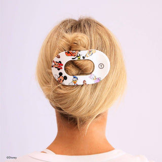 Woman wearing white oval hair clip with Disney Mickey and Friends characters in blonde updo hairstyle.