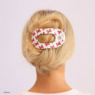 Woman wearing white oval hair clip with red Minnie Mouse bow pattern in blonde updo hairstyle
