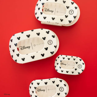 Four white hair clips with black Mickey Mouse pattern displayed on red background