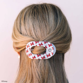 Woman wearing white oval hair clip with red polka dot bow pattern in blonde hair