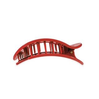 Red curved hair clip with vertical slat design and extended handle for styling