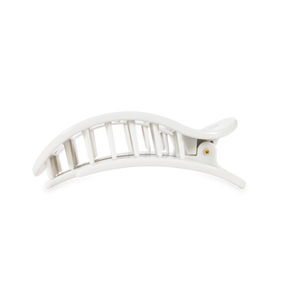 White flat round hair clip with geometric cutout pattern and gold accent detail