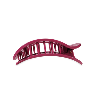 Pink curved hair clip with ridged grip design and tail extension
