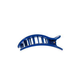 Blue curved hair clip with rectangular cutout pattern and metal rivet detail