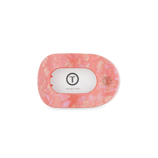 TELETIES flat round hair clip in translucent coral pink with branded label on black stand