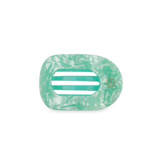 Clear green flat round hair clip with decorative cut pattern on white background
